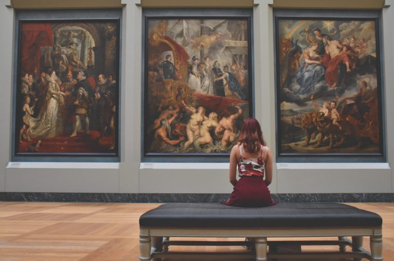 woman-sitting-facing-three-paintings-museum