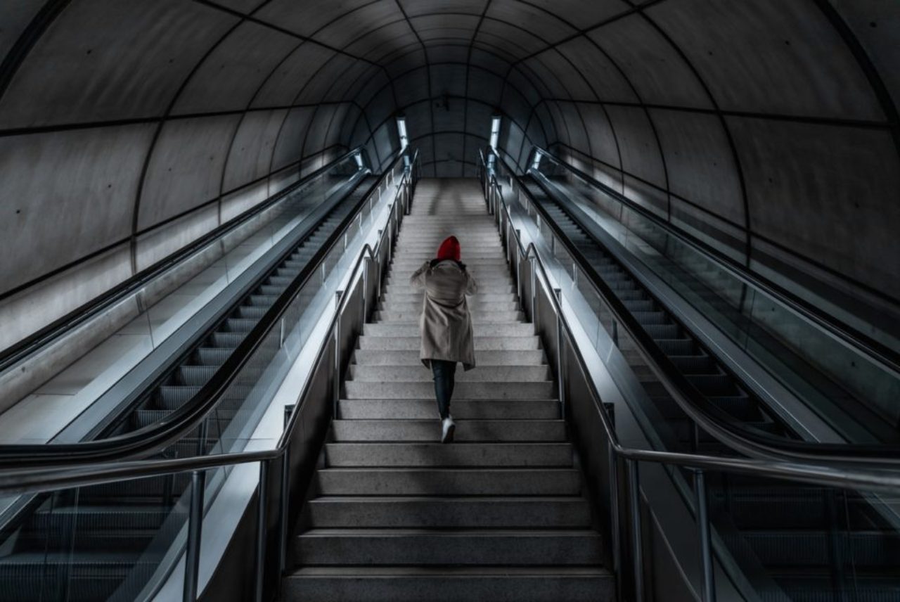 person-climbing-staircase-between-escalators